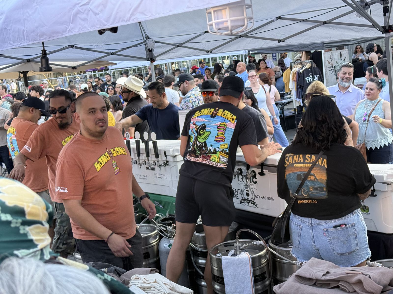 A crowd pouring beer from What Ale's Ya jockey boxes at an outdoor event